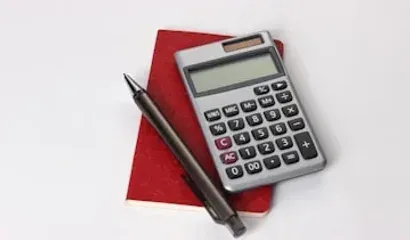 Calculadora e caderno sobre a mesa